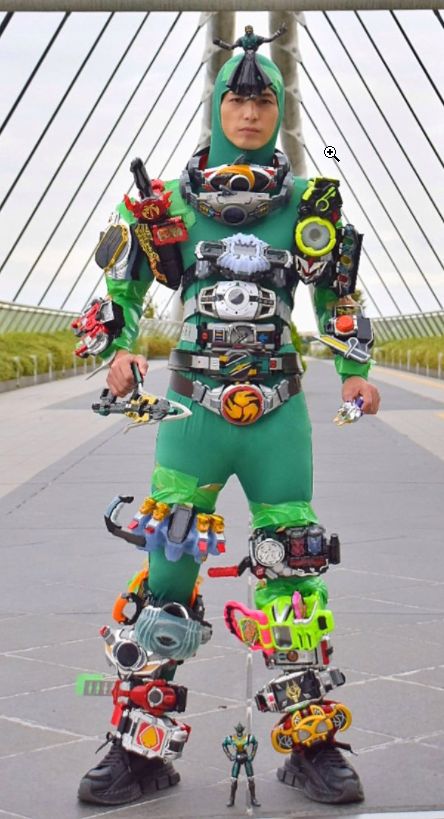 a man in a green suit with lots of gear on his feet and arms, standing next to a bridge