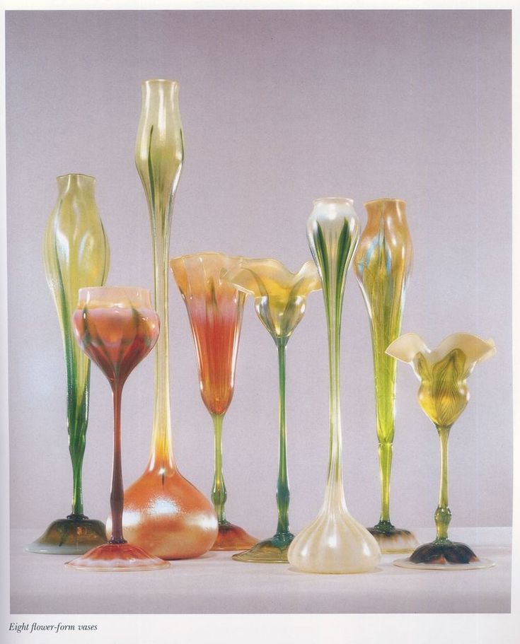 seven glass vases are lined up in a row