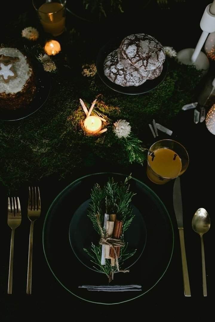 a table topped with plates and silverware covered in frosted cake next to candles