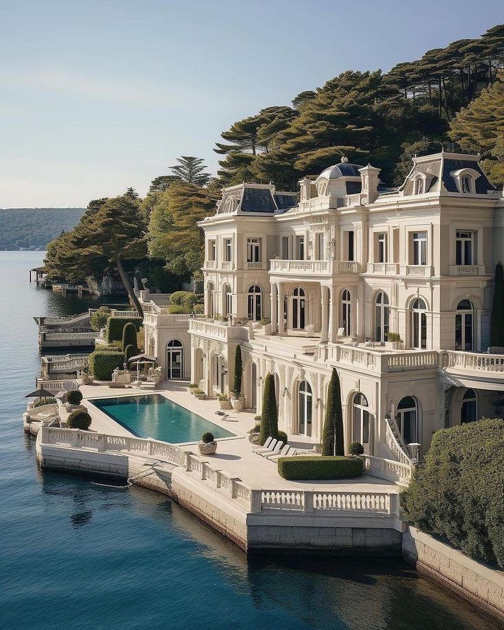 an aerial view of a mansion on the water