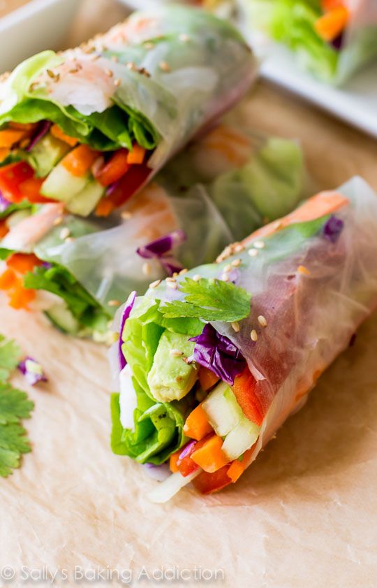 two rolls filled with veggies on top of a cutting board