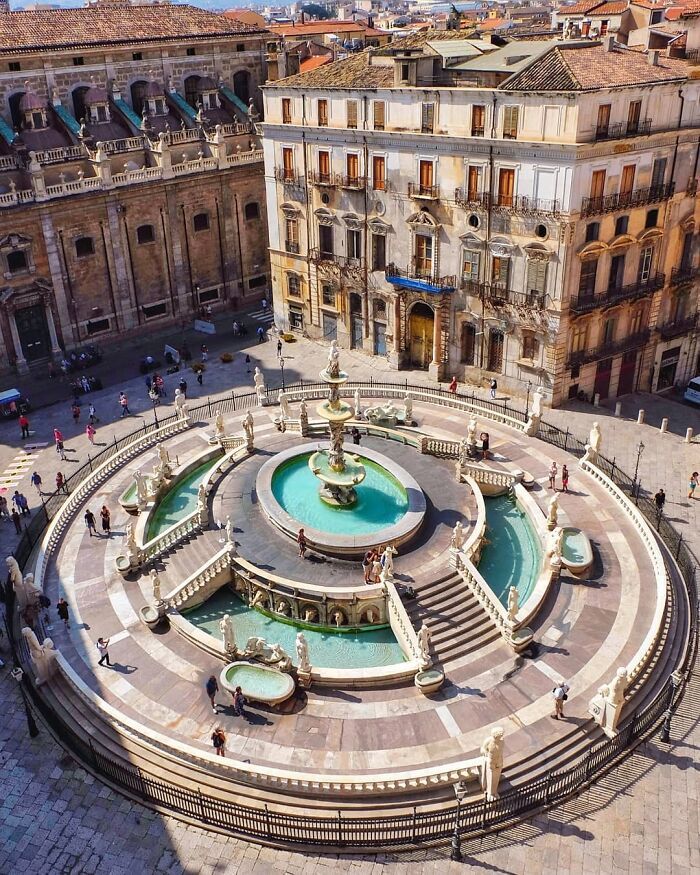 an aerial view of a fountain in the middle of a plaza