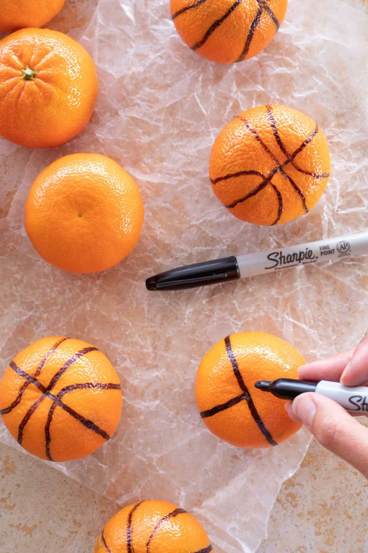 oranges with basketball painted on them are being used as markers to paint the tops