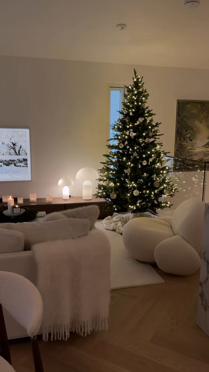 a living room filled with furniture and a lit christmas tree in the middle of it