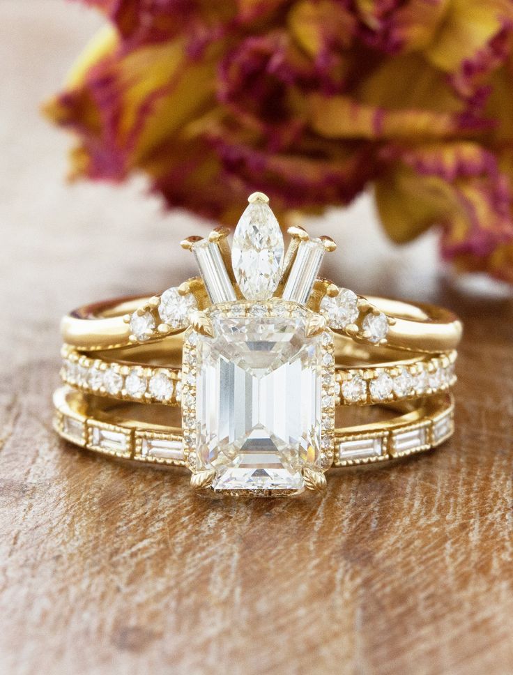 a close up of a ring on a table with flowers in the background