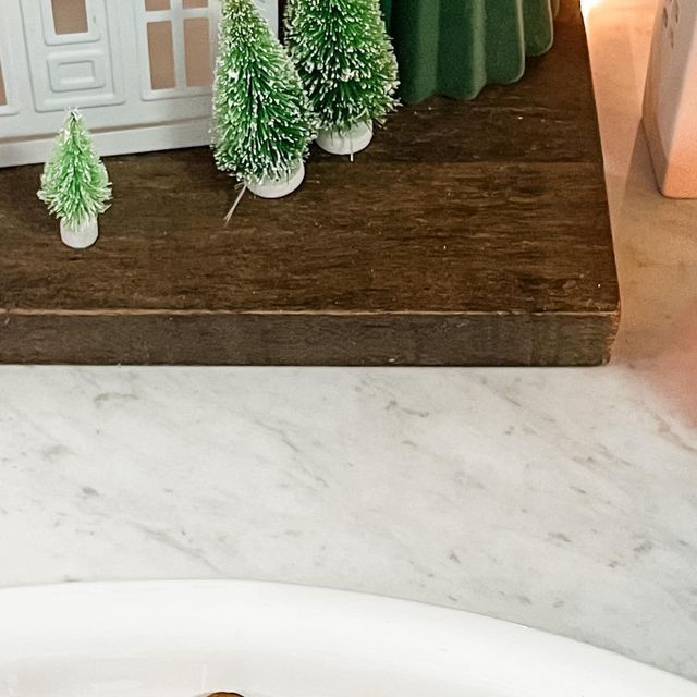 a piece of chocolate cake sitting on top of a white plate next to small trees