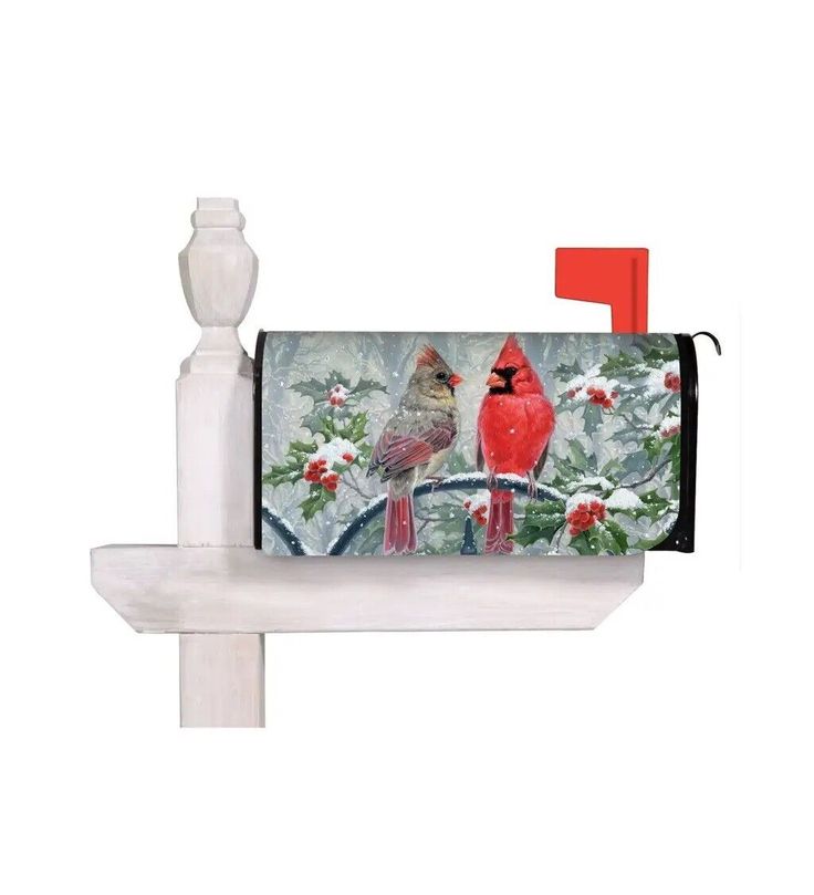 a mailbox with two cardinals on it and holly decorations around the edges, sitting on a white post