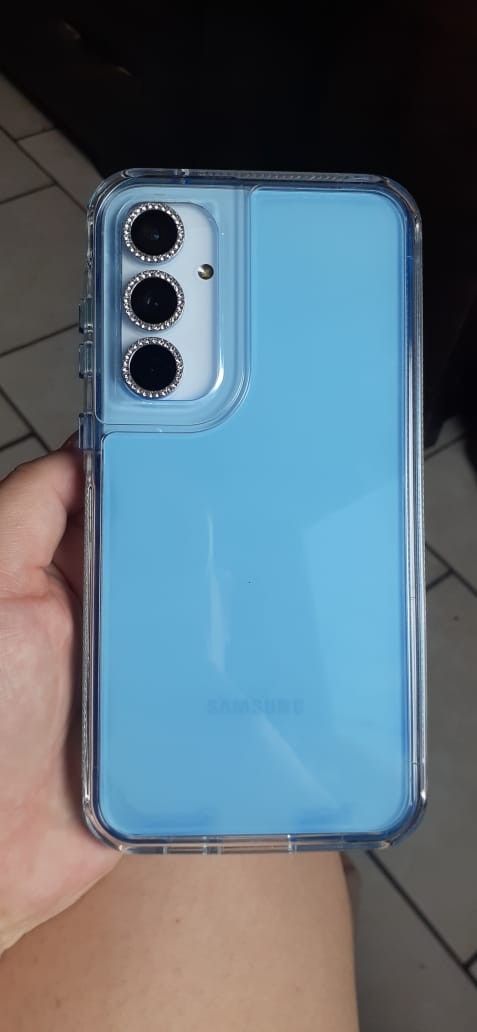 a person holding up a blue case with three buttons on the front and bottom of it