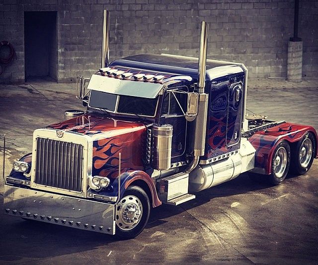 a semi truck painted with red, white and blue designs