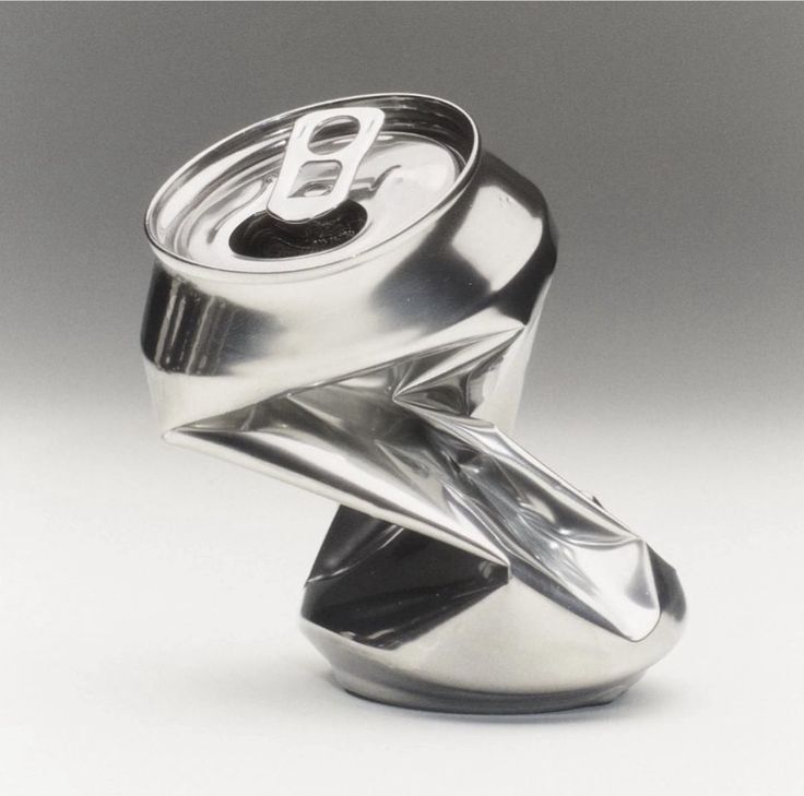 a soda can is sitting on top of a metal object that looks like it has been folded over