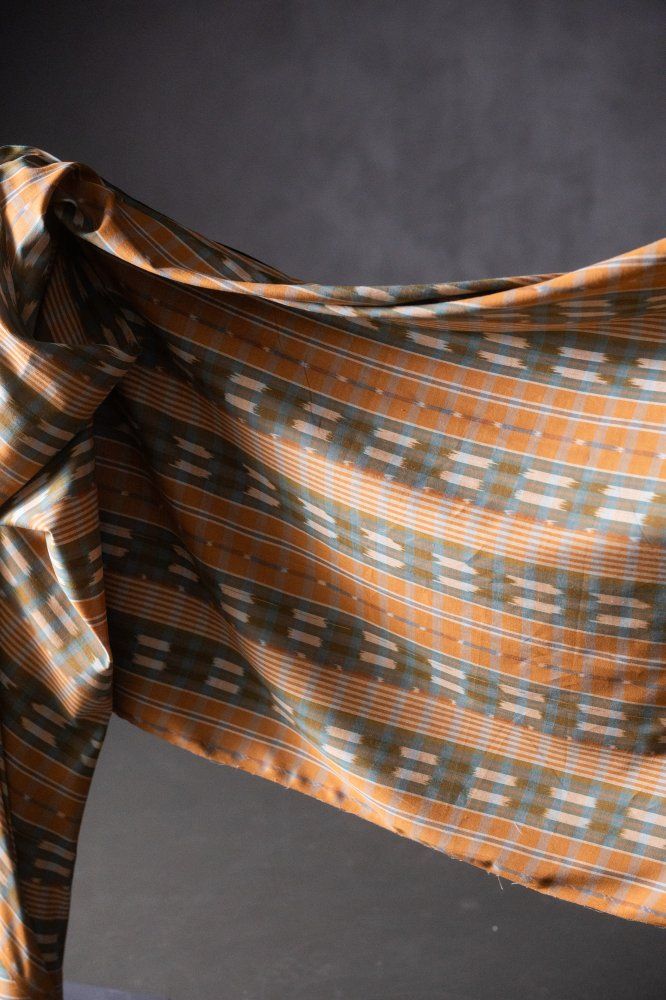 an orange and blue plaid fabric with folds