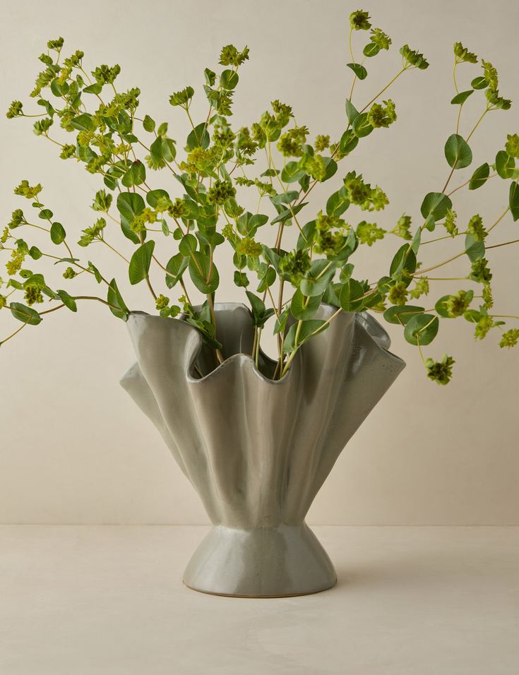 a vase filled with lots of green plants