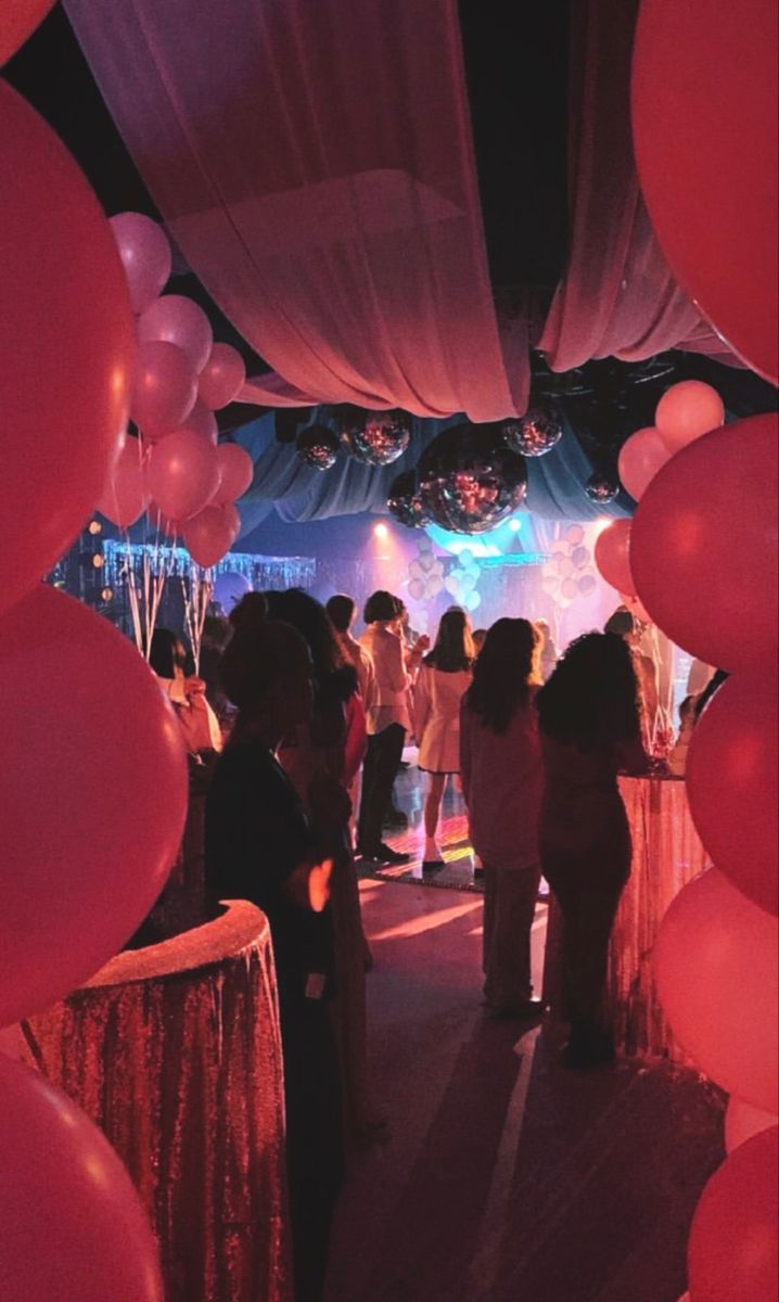 a group of people that are standing under some balloons