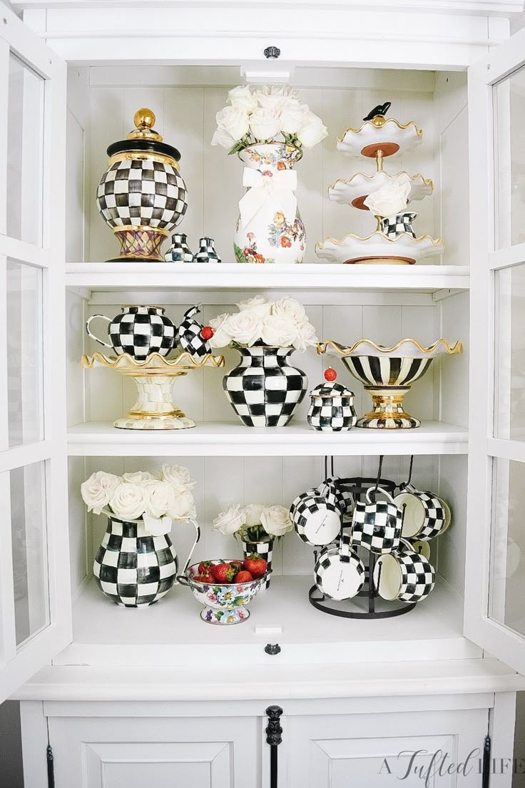 a white shelf filled with vases and other decorative items on top of eachother