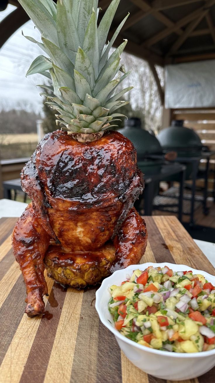 a large pineapple sitting on top of a table next to a bowl of salad