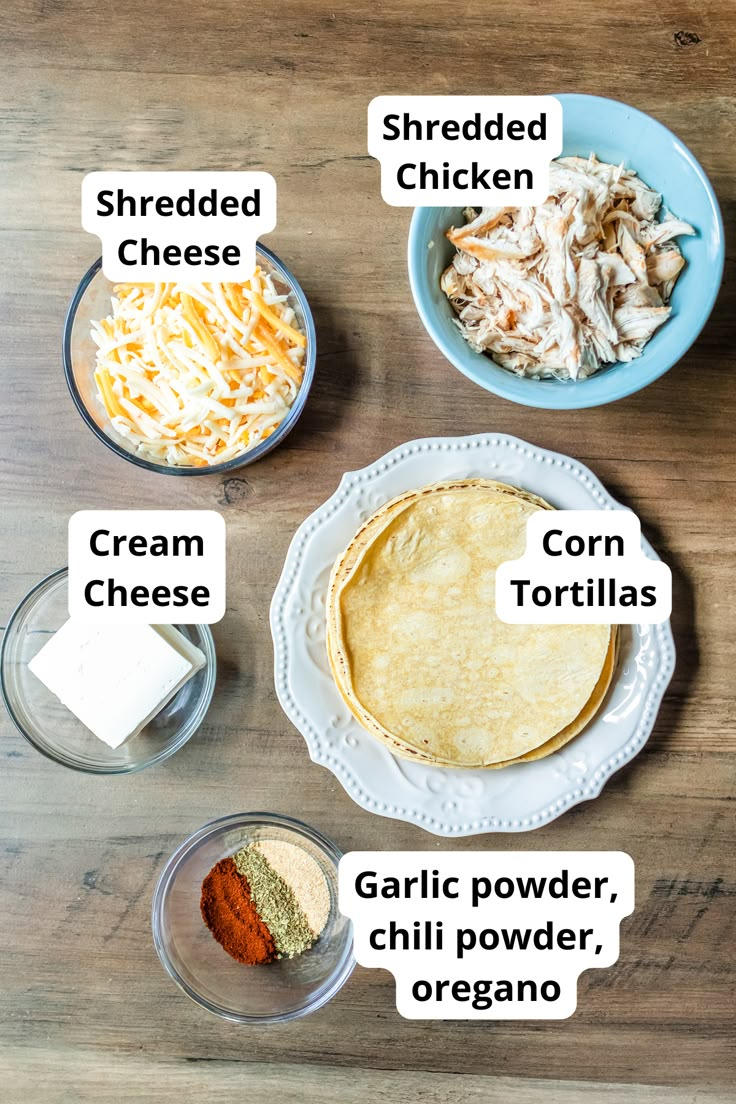 ingredients to make chicken quesadilla laid out on a wooden table, including shredded cheese and corn tortillas