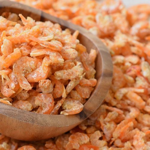 a wooden spoon filled with chopped carrots on top of a table