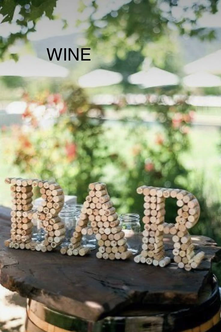 wine bottle caps spelling out the word dad on top of a wooden barrel filled with rocks