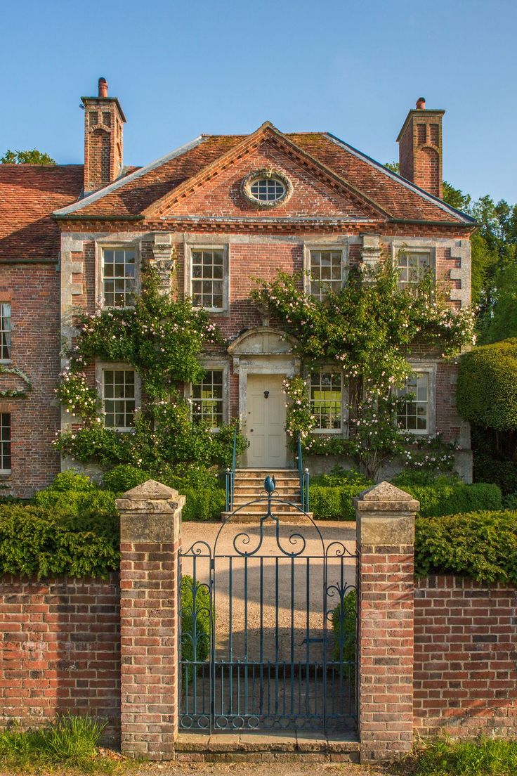 a large brick house with an iron gate