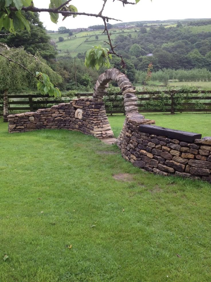 an old stone wall in the middle of a field