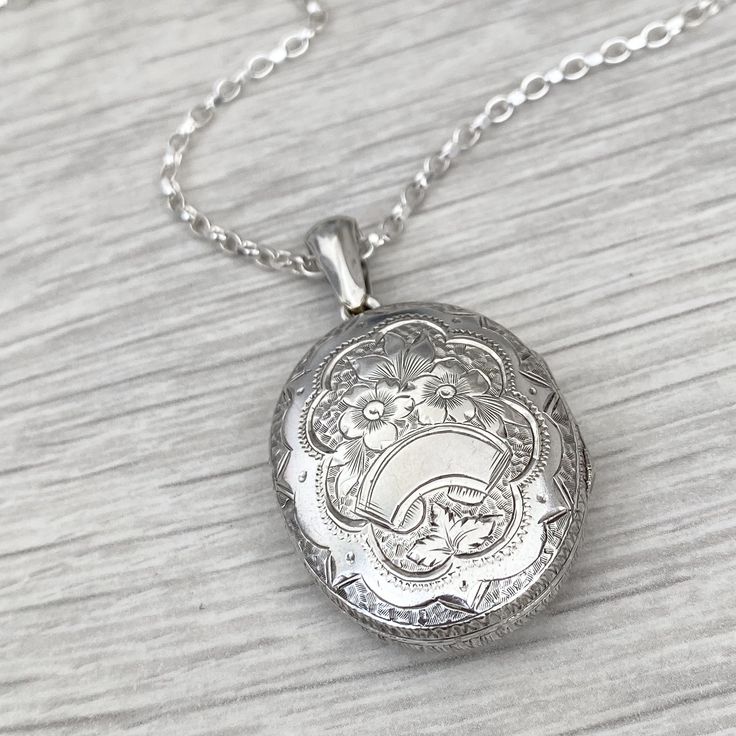 Pre - Owned Vintage British Jewellery  Vintage silver large oval engraved locket pendant  Locket size - 32mm x 25mm ( with bail 45mm in length) A new silver 2.2mm wide trace 28 inch chain (can be shortened) Locket and chain weight - 14.58g Not hallmarked or stamped  Condition - Great condition. This item comes in a lovely branded gift box Part of this item is second hand so the condition is not 100% perfect as you would expect from a brand new item! It has however been cleaned and refinished to