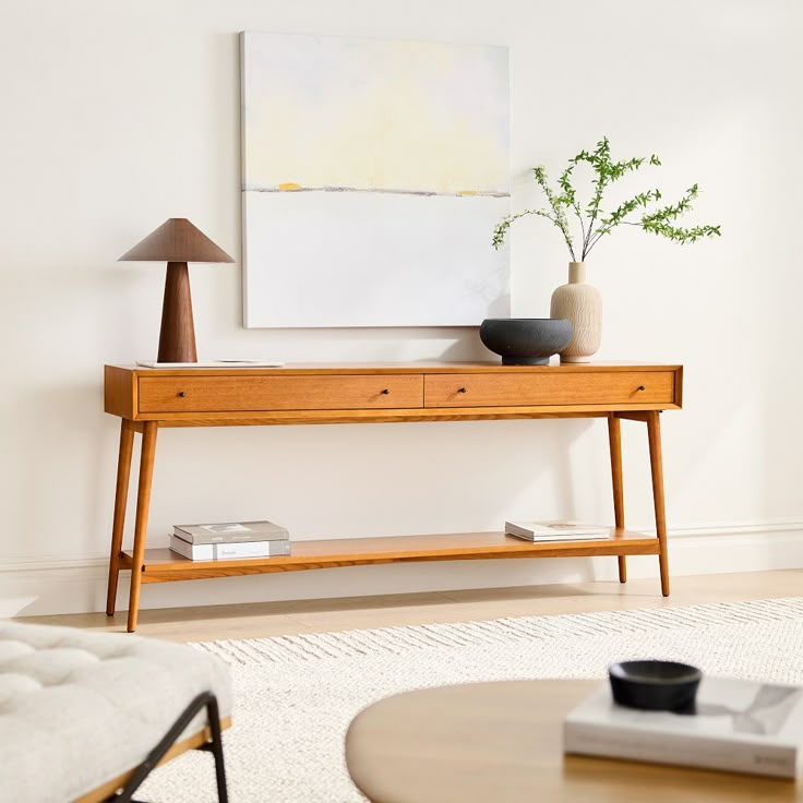 a living room with a table and two vases on top of it, in front of a painting