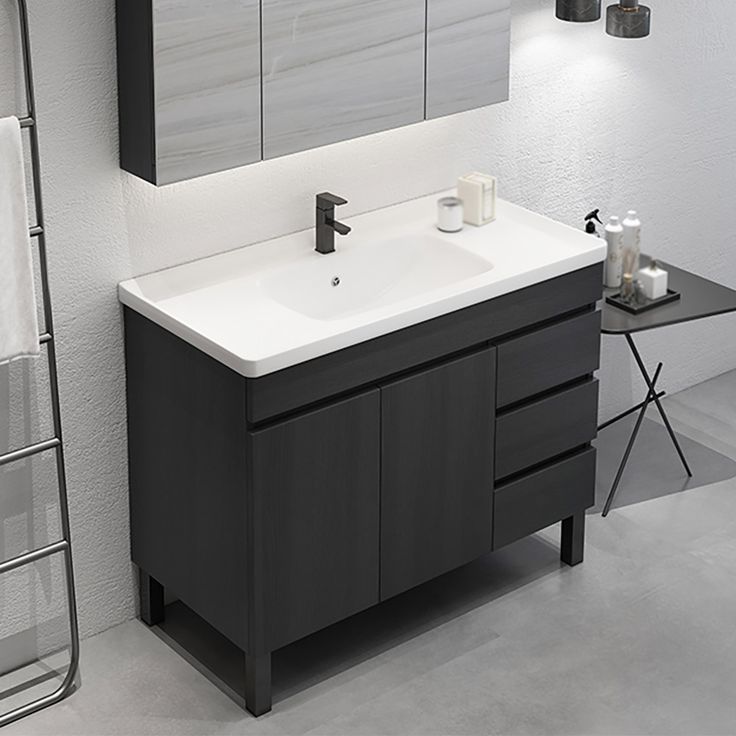 a bathroom with a sink, mirror and towel rack