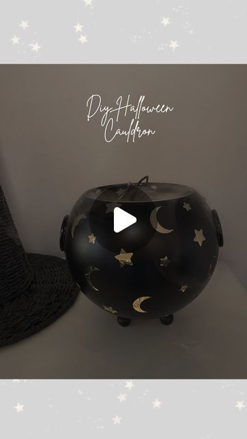 a black vase with stars and moon designs on it