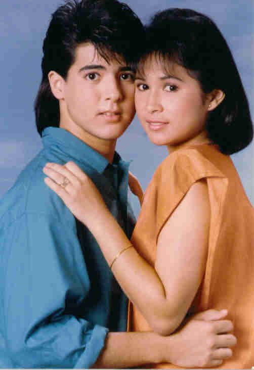 a man and woman hugging each other in front of a blue background