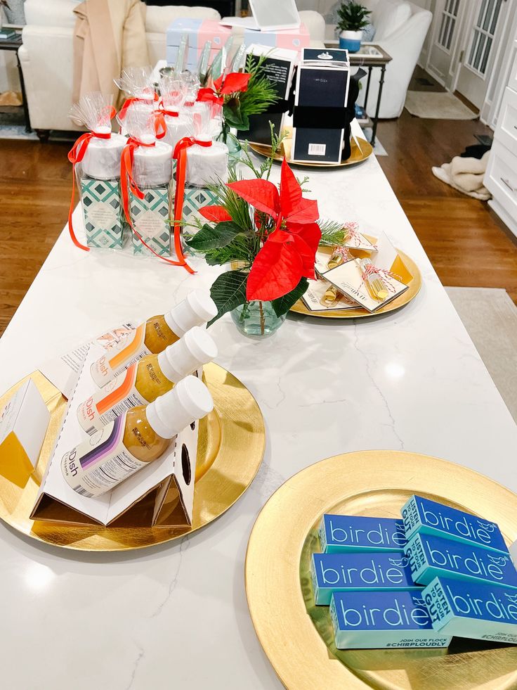 the table is decorated with gold plates and red poinsettia flowers on them