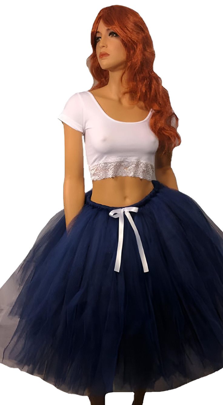 Step into elegance and grace with our Beautiful Navy Blue Tutu Skirt. This stunning skirt is perfect for any occasion, whether it's a special event, a party, or simply a day when you want to feel extra special. The skirt is meticulously crafted by tying hundreds of pieces of tulle to a comfortable elastic band. This technique creates a full and voluminous look, giving the skirt a mesmerizing and fluffy appearance. The deep navy blue color adds an element of sophistication, making you stand out with style and confidence. To add a touch of elegance, the skirt is adorned with a delicate white satin bow, creating a beautiful contrast against the navy blue tulle. This subtle detail adds an extra layer of charm and completes the overall look. Measuring at a length of 25 inches, this tutu skirt f Blue Tutu Skirt, Blue Tutu, Deep Navy Blue, Blue Tulle, Fall Skirts, White Bow, Satin Bow, Womens Skirts, Navy Blue Color