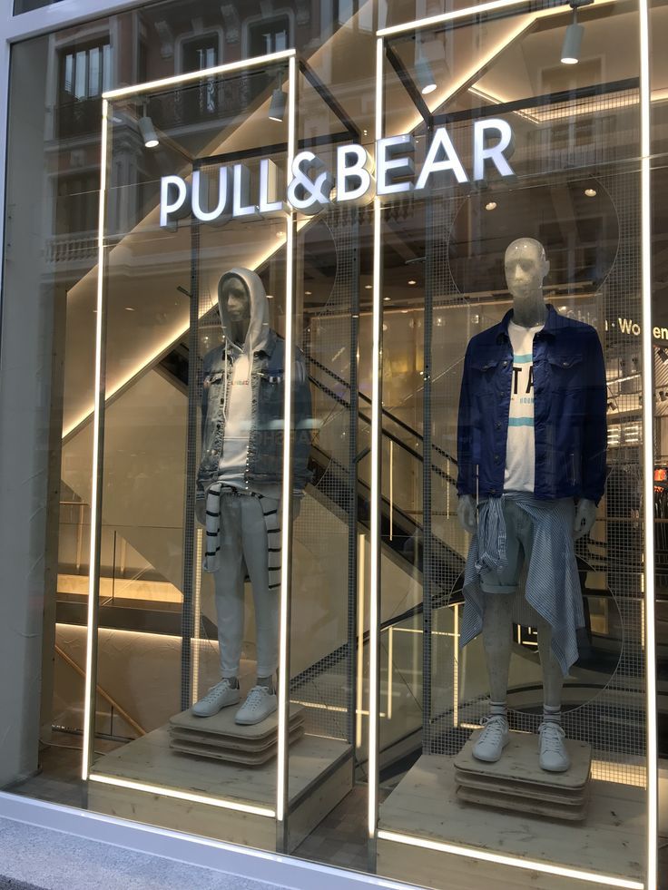 two mannequins in front of a store window with pull & bear clothing on display