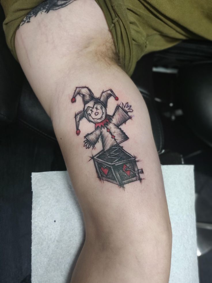 a tattoo on the leg of a man with a creepy clown figure in it's arm