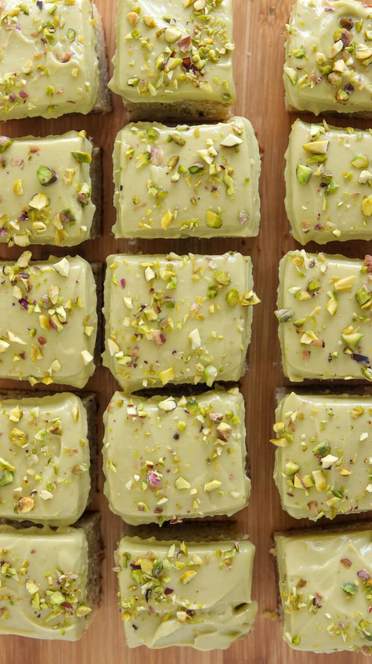 several pieces of cake sitting on top of a wooden cutting board covered in frosting