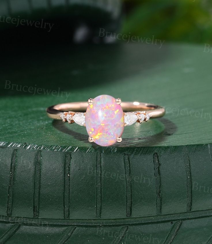 an opal and diamond ring sits on top of a tire