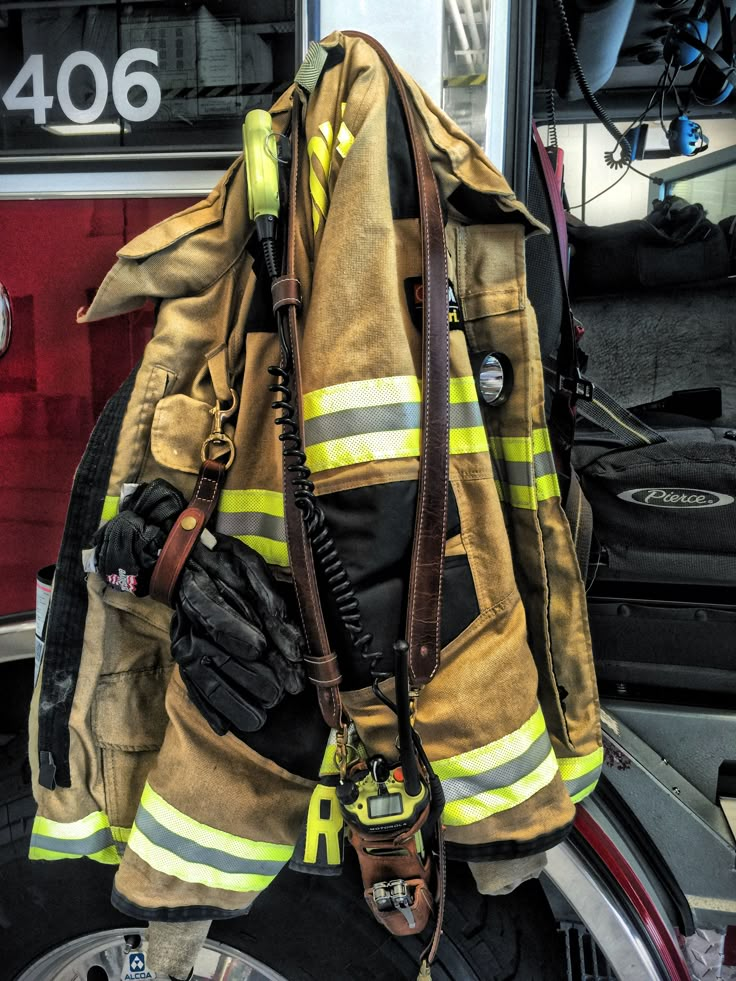 a fireman's gear hanging on the back of a motorcycle