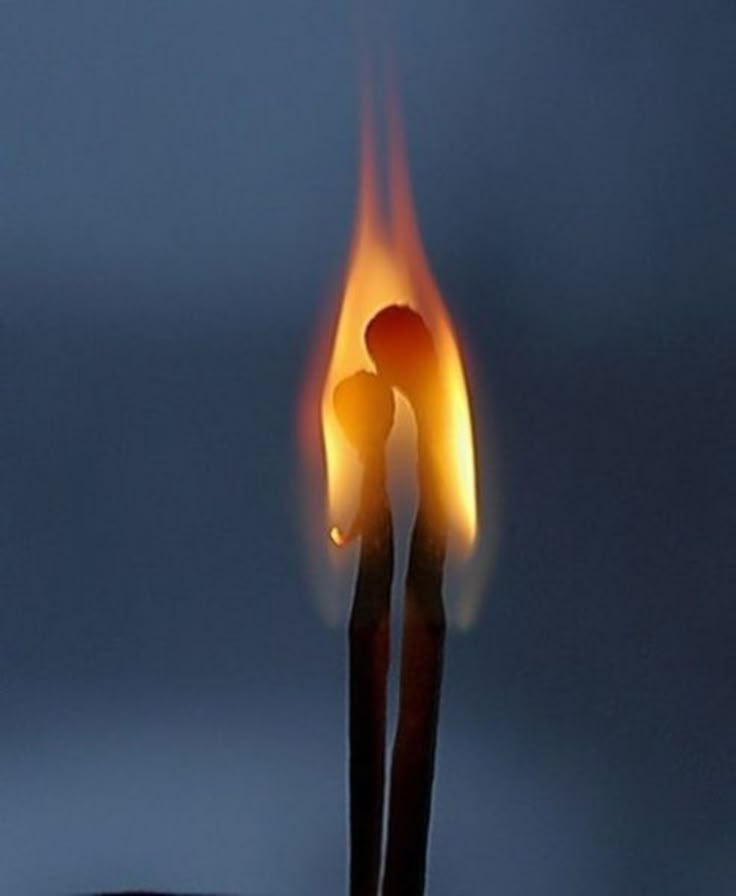 a matchstick is lit up in the dark with flames coming out of it's ends