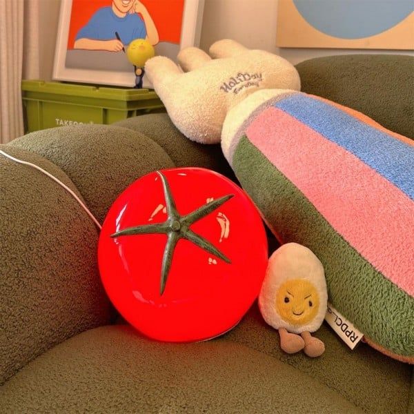 two stuffed animals sitting on top of a green chair next to a red bowl and starfish pillow