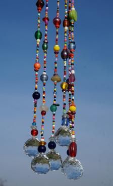 a wind chime hanging in the air with lots of beads on it's sides