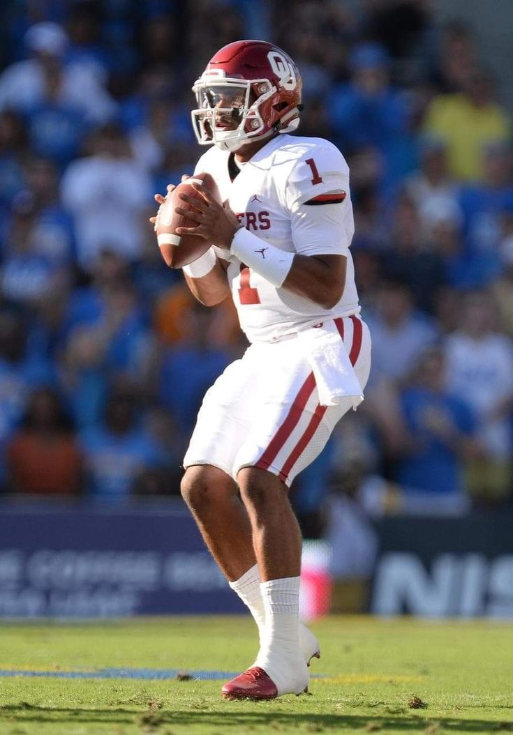 a man holding a football on top of a field