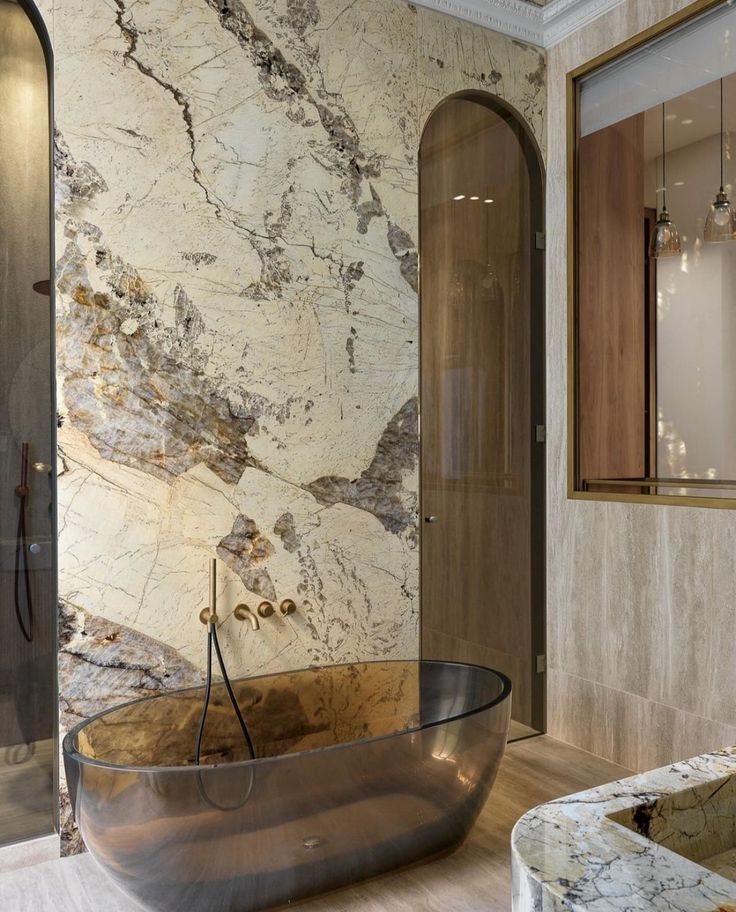 a bathtub in the middle of a bathroom with marble walls and flooring on both sides