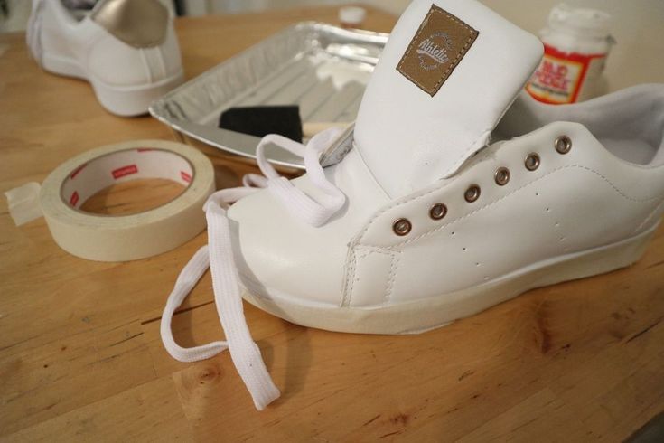 a pair of white shoes sitting on top of a wooden table