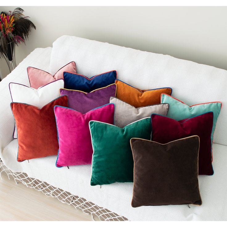 a bunch of pillows sitting on top of a white couch