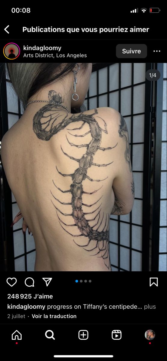 the back of a woman's body with tattoos on it