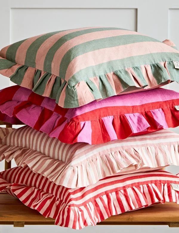 four pillows stacked on top of each other with ruffles and stripes in different colors