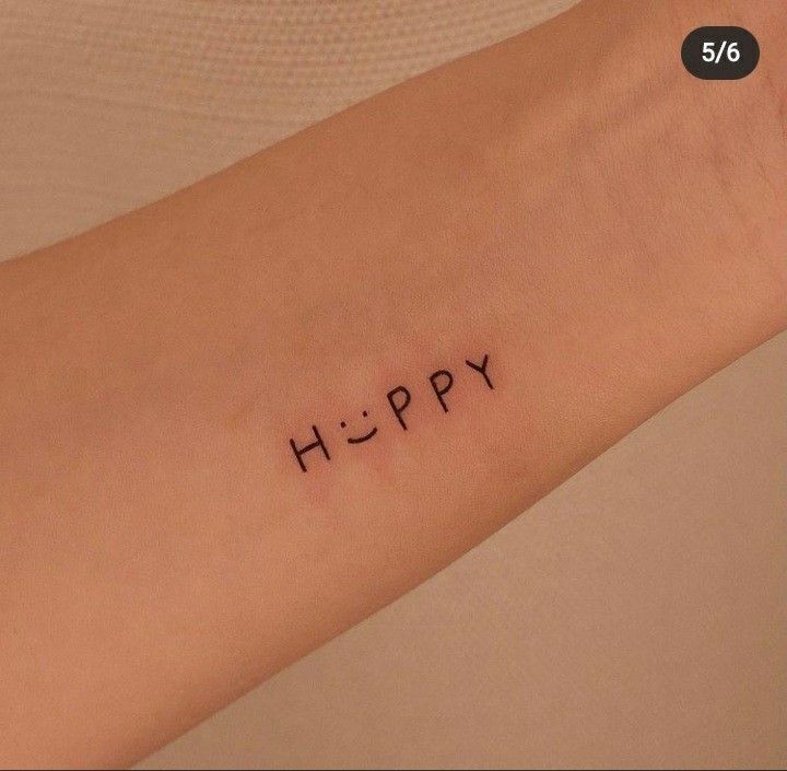 a woman's arm with the word happy written in small black ink on it