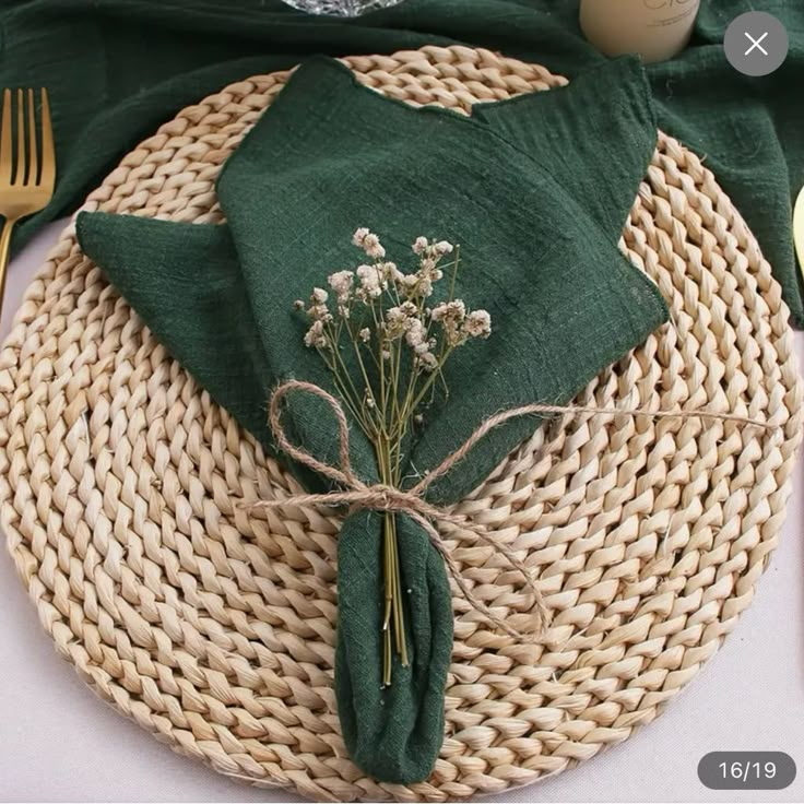 a place setting with green napkins and flowers