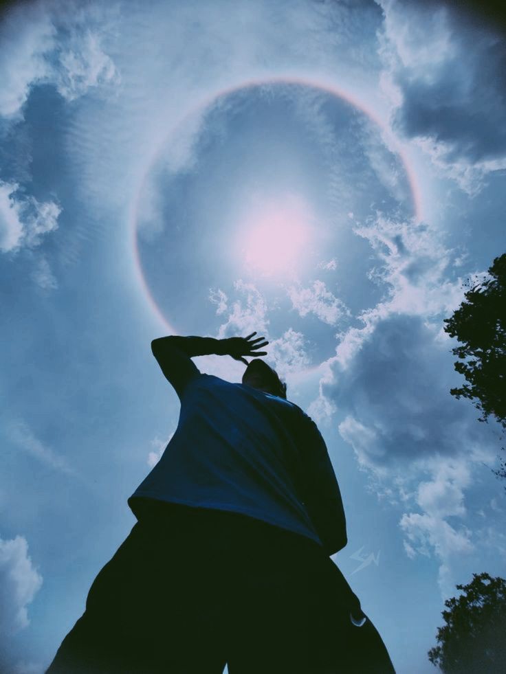 a man reaching up into the sky to catch a frisbee in his hand