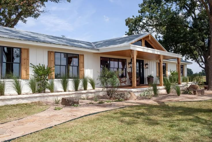 a small white house with wood trim and windows