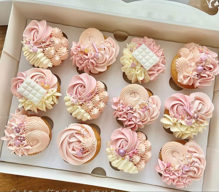 cupcakes in a box decorated with pink and white icing